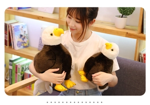 Dettaglio di due peluche a forma di aquila calva di diverse dimensioni tenuti in mano