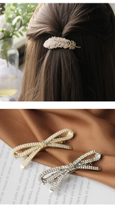 Detail of feather and bow hair clips with pearls and rhinestones on hair and fabric