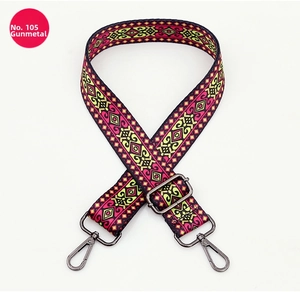 Close-up of geometric pattern bag strap with gunmetal swivel hooks and adjustable buckle