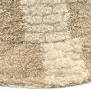 Vue détaillée de la texture douce en fausse fourrure à carreaux d'un bob d'hiver beige
