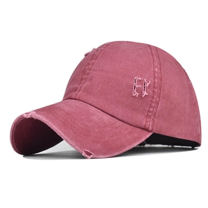 Side view of washed pink baseball cap with distressed details and FF embroidery