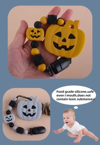 Detail of food grade silicone pacifier clip with pumpkin design and safety features
