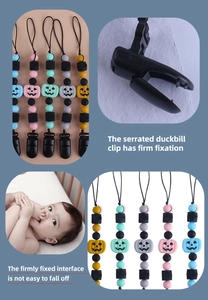 Detail of five silicone baby pacifier clips with pumpkin beads and secure plastic fasteners