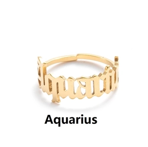 Macro shot of gold Aquarius zodiac ring featuring elegant cursive lettering design