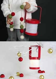 Red portable lantern night light with white folding shade used as Christmas decoration