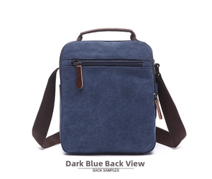 Detailed back view of dark blue canvas messenger bag with zippered pocket and brown straps