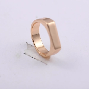 Macro detail of rose gold rectangular flat ring with a smooth polished finish and minimal design