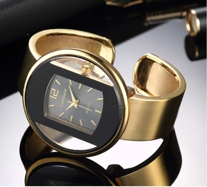 Dettaglio macro di un orologio a bracciale dorato con quadrante nero e finitura lucida