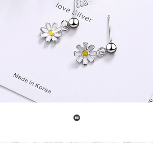 Detailed close-up of daisy stud earrings with white enamel petals and yellow center