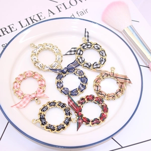 Close-up of colorful plaid ribbon metal pendants with bows on a white ceramic plate