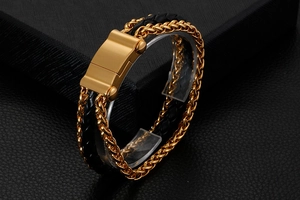 Macro shot of double-layered black woven leather and polished gold steel men's bracelet