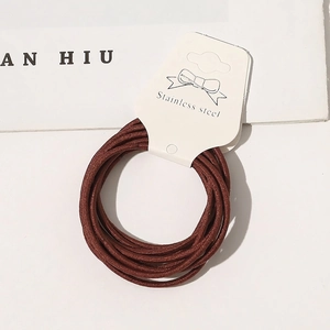 Detail of high-elastic coffee brown hair ties on a display card with bow accents