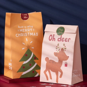 Christmas gift bags with festive tree and reindeer patterns on a dark blue background