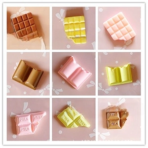 Macro detail of assorted mini resin chocolate charms in brown and pink for DIY crafts