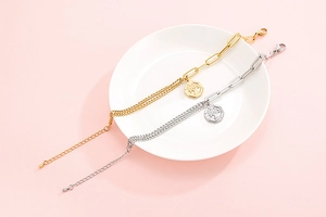 Detail des Lebensbaum-Anhängers an asymmetrischen Gold- und Silberarmbändern