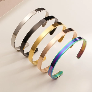 Detailed set of five C-shaped stainless steel cuff bracelets in assorted polished finishes