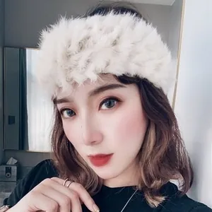 Close-up of white plush faux fur headband showing soft texture and winter style detail