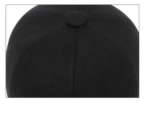 Detail of six-panel crown stitching and fabric button on black cotton baseball cap