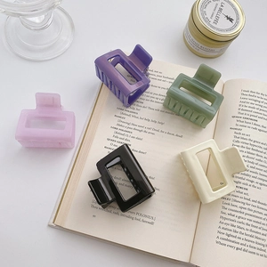 Medium acrylic hair claws in five colors on book for elegant Korean style hair styling