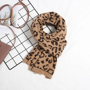 Detailed view of leopard print knit scarf with ribbed edges and soft winter texture