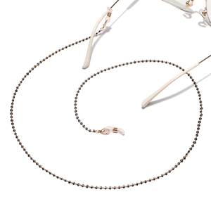 Handmade golden eyewear chain with black beads and silicone anti-slip rings on white backdrop