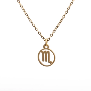 Macro detail of gold Scorpio constellation pendant necklace with polished circle frame