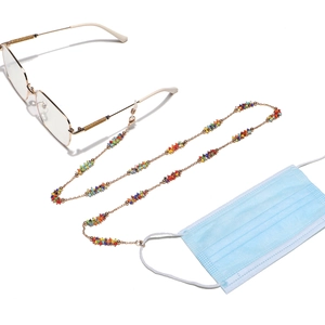 Handmade colorful beaded eyeglass and mask chain with gold metal links on white background