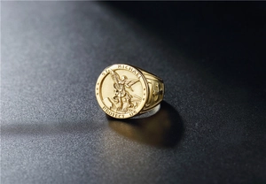 Macro shot of gold St. Michael ring detail with embossed archangel and protective prayer