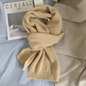Soft oatmeal knit ribbed winter scarf for women styled with wool coat and magazines