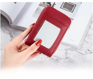 Close-up of red lychee texture card holder with ID window and gold zipper detail