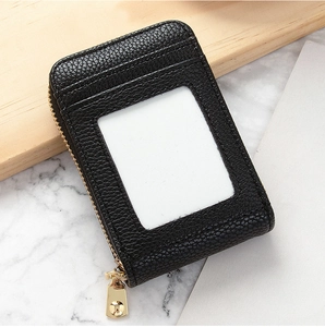 Detail of black lychee leather card holder with gold zipper and transparent ID window