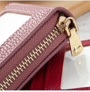 Macro shot of litchi texture leather card holder with gold zipper and clear ID window