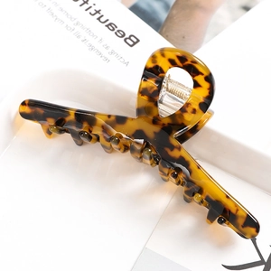 Close-up of tortoise shell pattern hair claw clip with glossy finish and metal spring