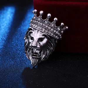 Detailed close-up of retro silver lion head brooch with crown and crystal rhinestones