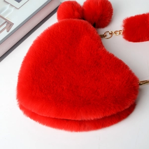 Close-up of red heart-shaped plush bag with fluffy faux fur texture and gold chain