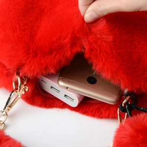 Detail view showing internal capacity of red faux fur heart bag with golden hardware