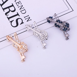 Vue détaillée de broches violon en or, argent et bronze avec des strass étincelants