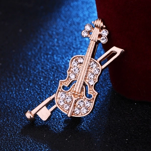 Broche violon classique dorée avec cristaux sur fond texturé bleu marine