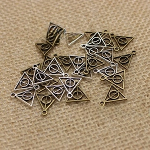 Mix van zilveren en bronzen Relieken van de Dood hangers op jute ondergrond