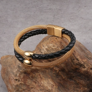 Double-layer braided black leather and gold chain bracelet with magnetic clasp on wood
