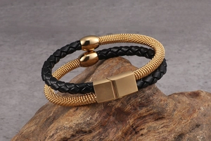 Detail of double-layer black leather braided bracelet with gold mesh and magnetic clasp