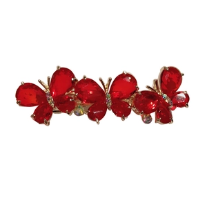 Elegant gold butterfly hair barrette with faceted red crystals on a white background