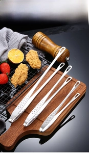 Three-piece stainless steel kitchen tweezers set with non-slip handles on a wooden board