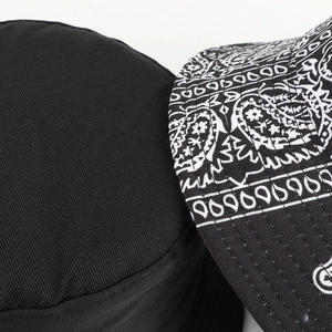 Close-up of black paisley cotton bucket hat showing stitching and pattern detail