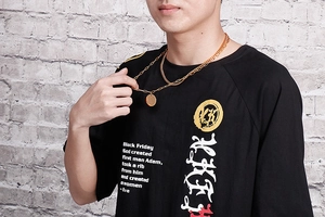 Close-up of golden double-layer chain necklace with a round pendant on a model