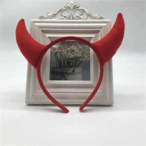 Detail showing the red plush devil horns headband placed in front of a white photo frame