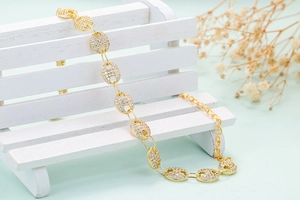Detail of 18K gold coffee bean chain link bracelet with sparkling pavé cubic zirconia