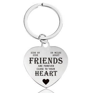 Close-up of heart keychain with engraved friendship quote on polished stainless steel