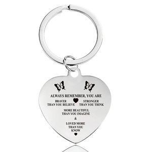 Detail of silver heart keychain with engraved inspirational quote and butterfly icons