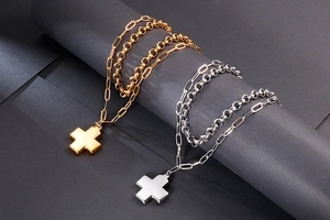 Detail of double-layer stainless steel cross pendant necklace in gold and silver finish